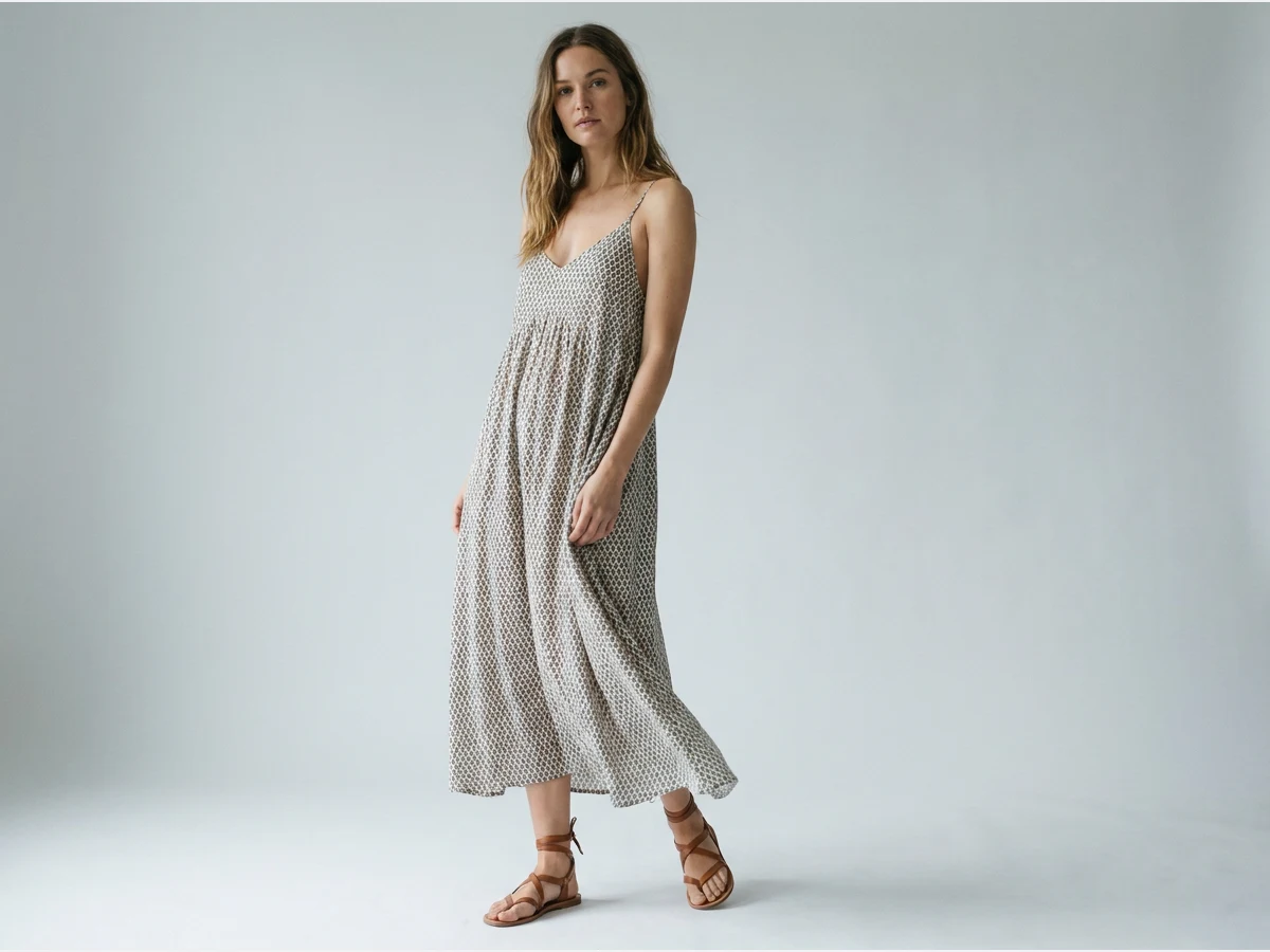 a model photographed to show footwear, sandals with a summer dress