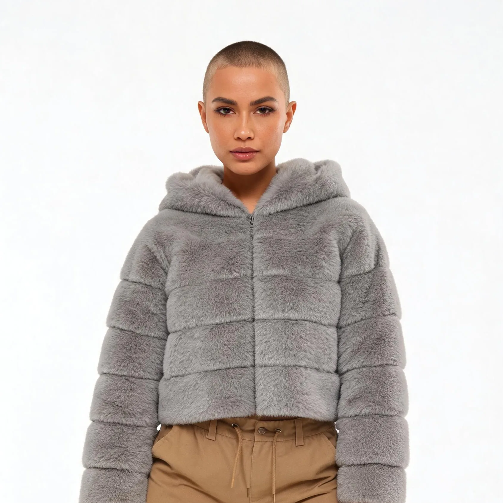 A model wearing a cropped gray faux fur hooded jacket over beige trousers